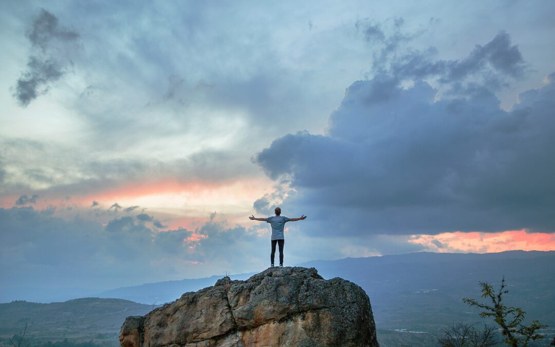 Man joyful on mountain, overcoming anxiety